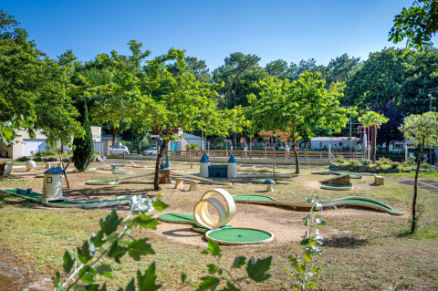 Parcours de mini-golf entouré d’arbres au Flower Camping Au Bois Des Biches, Pays de la Loire, France.