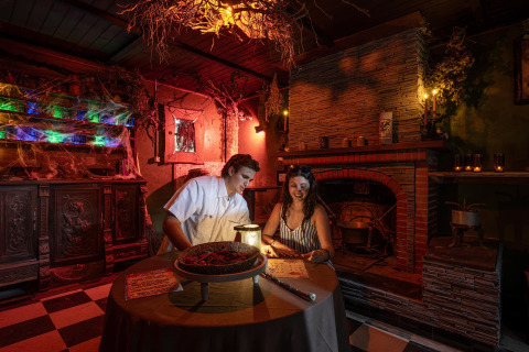 Two people enjoy a witch-themed escape room at Flower Camping Au Bois Des Biches in Pays de la Loire, France.