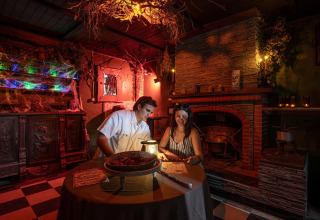 Dos personas participan en una sala de escape temática sobre brujas en Flower Camping Au Bois Des Biches, Francia.