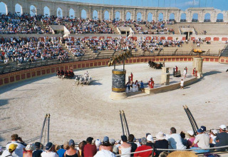 Publiek geniet van een nagebootste Romeinse wagenrace in een amfitheater in Pays de la Loire, Frankrijk.