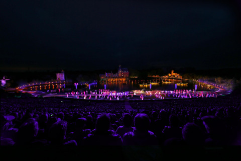 Evening show with colorful lights, audience, and stage at Flower Camping Au Bois Des Biches, Pays de la Loire.