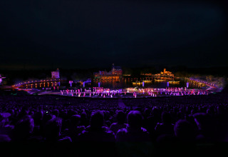 Evening show with colorful lights, audience, and stage at Flower Camping Au Bois Des Biches, Pays de la Loire.