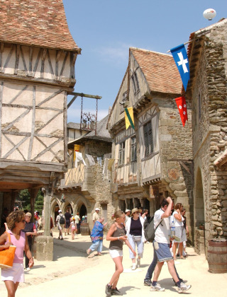 Menschen spazieren durch ein mittelalterliches Dorf mit Fachwerkhäusern nahe Saint Hilaire de Riez in Frankreich.