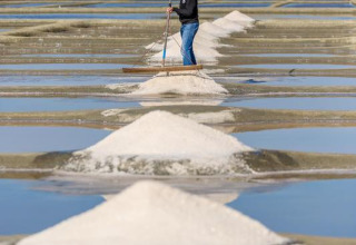 Un trabajador apila montones de sal en salinas en Flower Camping Au Bois Des Biches, Pays de la Loire, Francia.