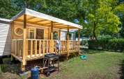 Außenansicht des Stacaravan Confort mit überdachter Terrasse auf Flower Camping Au Bois Des Biches in Frankreich.