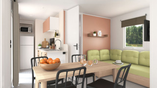 Lichte woonkamer en keuken in het Stacaravan Confort PLUS chalet met eettafel en groene zetel.