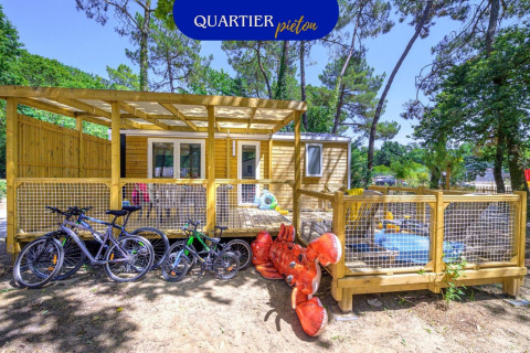 Buitenaanzicht van het Stacaravan Family chalet met fietsen, speelzone en grote opblaasbare kreeft.