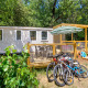 Chalet Stacaravan Family con terrazza, biciclette e verde circostante, ideale per vacanze in famiglia.