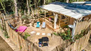 Vue aérienne du chalet Stacaravan Garden avec terrasse en bois, transats, hamac et jardin clôturé.