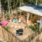 Luchtfoto van het Stacaravan Garden chalet met houten terras, ligstoelen, hangmat en omheinde tuin.