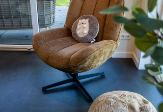 Sillón y puf acogedores en Wood Cottage + hot tub, Holiday park De Witte Berg en los Países Bajos.