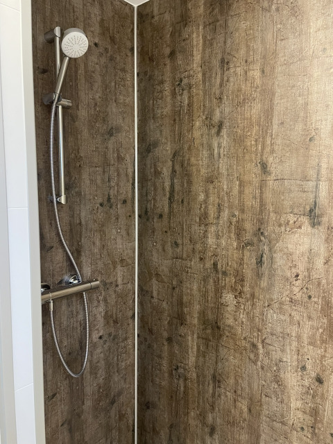 Doccia con pareti effetto legno in un lodge al Holiday park De Witte Berg, Paesi Bassi.