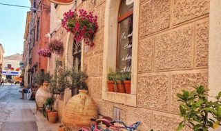Calle colorida en Funtana, Istria, Croacia, con flores, bicicletas pintadas y un ambiente acogedor y encantador.