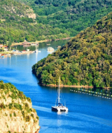 Un velero navega por un río bordeado de colinas verdes cerca de Funtana, en Istria, Croacia.