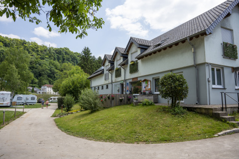 Camping du Rivage holiday park in Diekirch, Luxembourg with caravans, green landscape and modern buildings.