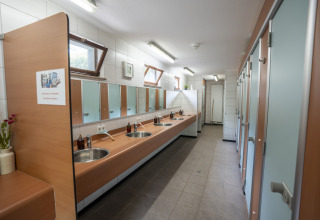 Bagno comune con lavandini e specchi al Camping du Rivage, parco vacanze a Diekirch, Lussemburgo.