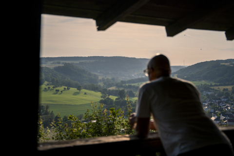 A person gazes over the lush countryside from a balcony at Camping du Rivage in Diekirch, Luxembourg.