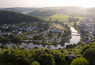Vista aerea di Camping du Rivage a Diekirch, Lussemburgo, con fiume, ponte e paesaggio naturale.