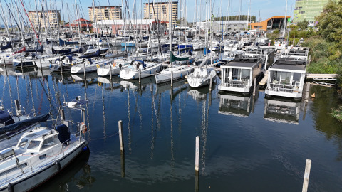 Vista de veleros y casas flotantes en Marina Parcs Almere, Países Bajos, en un día soleado y claro.
