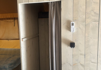 Interno della tenda safari Cottage al campeggio Vilanova Park in Spagna con pareti in legno e angolo cucina.