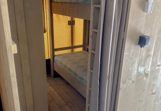 Blick in ein Safari-Zelt mit Etagenbett und Schrank im Cottage von Vilanova Park Campingplatz in Spanien.