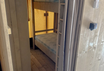 Binnenaanzicht van een safaritent met stapelbed en kast op Vilanova Park Camping in Spanje.