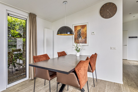 Eethoek in Natuurlodge bij Recreatiepark het Esmeer, Nederland, met moderne inrichting en tuinzicht.