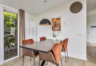 Coin repas à la Natuurlodge du Recreatiepark het Esmeer, Pays-Bas, avec déco moderne et vue sur le jardin.