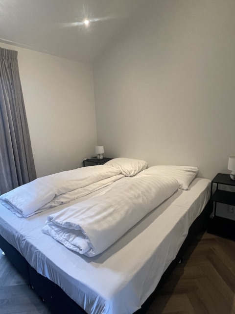 Habitación en Bos Cottage en De Thijmse Berg, Países Bajos, con cama doble y dos edredones separados.