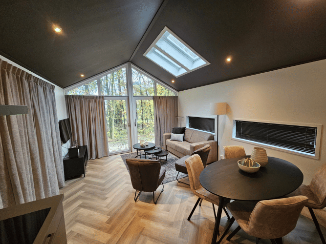 Moderno alojamiento Bos Cottage en De Thijmse Berg, Países Bajos, con amplios ventanales y decoración elegante.