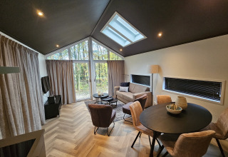 Moderno alojamiento Bos Cottage en De Thijmse Berg, Países Bajos, con amplios ventanales y decoración elegante.