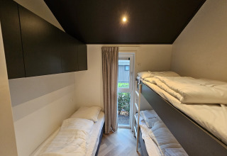Camera con letto singolo e letti a castello al Bos Cottage presso De Thijmse Berg, Paesi Bassi, moderna.
