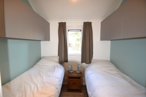 Schlafzimmer mit zwei Einzelbetten und Fenster, Eco Cottage, De Thijmse Berg, Niederlande.