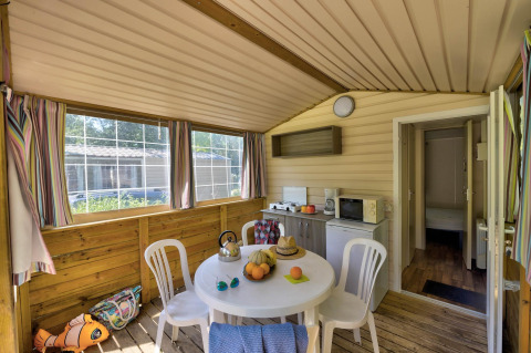 Vista interna della tenda safari Cabane Nature al Flower Camping Au Bois Des Biches con cucina e zona pranzo.