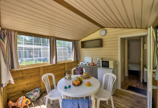 Vista interna della tenda safari Cabane Nature al Flower Camping Au Bois Des Biches con cucina e zona pranzo.