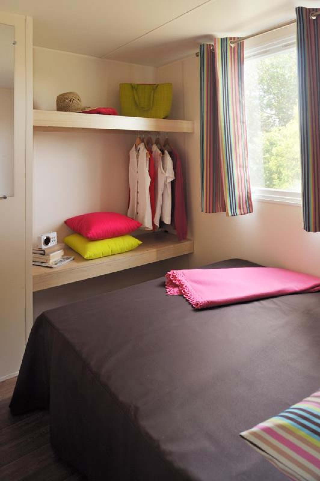 Slaapkamer in het Cabane Nature safaritent bij Flower Camping Au Bois Des Biches in Frankrijk met kleurige aankleding.