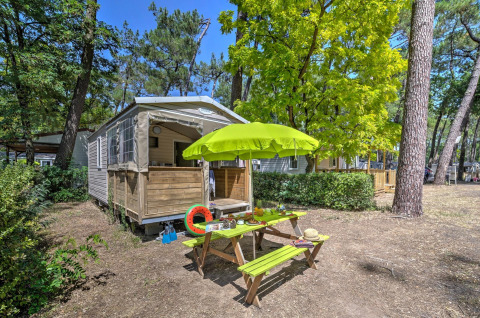 Tienda safari Cabane Nature en Flower Camping Au Bois Des Biches en Francia con mesa de picnic y sombrilla.