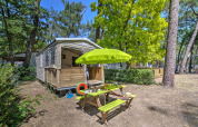 Safari-Zelt Cabane Nature auf dem Flower Camping Au Bois Des Biches in Frankreich mit Picknicktisch und Sonnenschirm.
