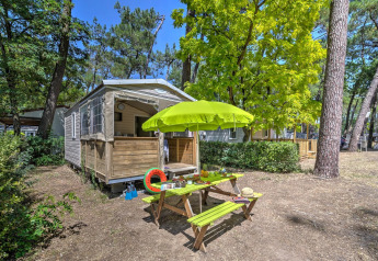 Tenda safari Cabane Nature al Flower Camping Au Bois Des Biches in Francia con tavolo da picnic e ombrellone.