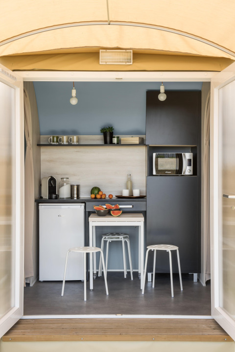 Køkkenområde i en safari-teltlodge med moderne faciliteter hos Flower Camping Au Bois Des Biches i Frankrig.