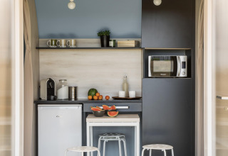 Zona de cocina de una tienda safari con comodidades modernas en Flower Camping Au Bois Des Biches, Francia.