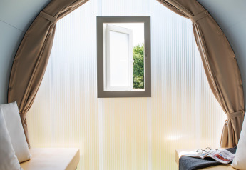 Binnenaanzicht van de Tent Lodge Coco Sweet safaritent met twee bedden en open raam bij Au Bois Des Biches.