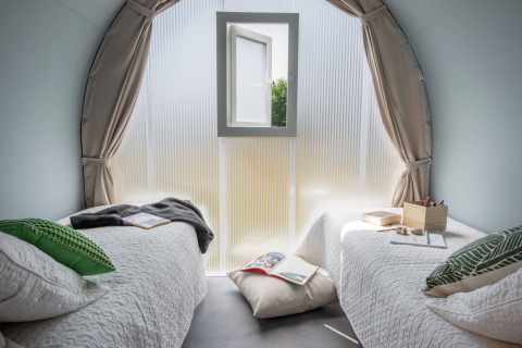 Vista interior de la tienda Safari Lodge Coco Sweet con dos camas en Flower Camping Au Bois Des Biches, Francia.