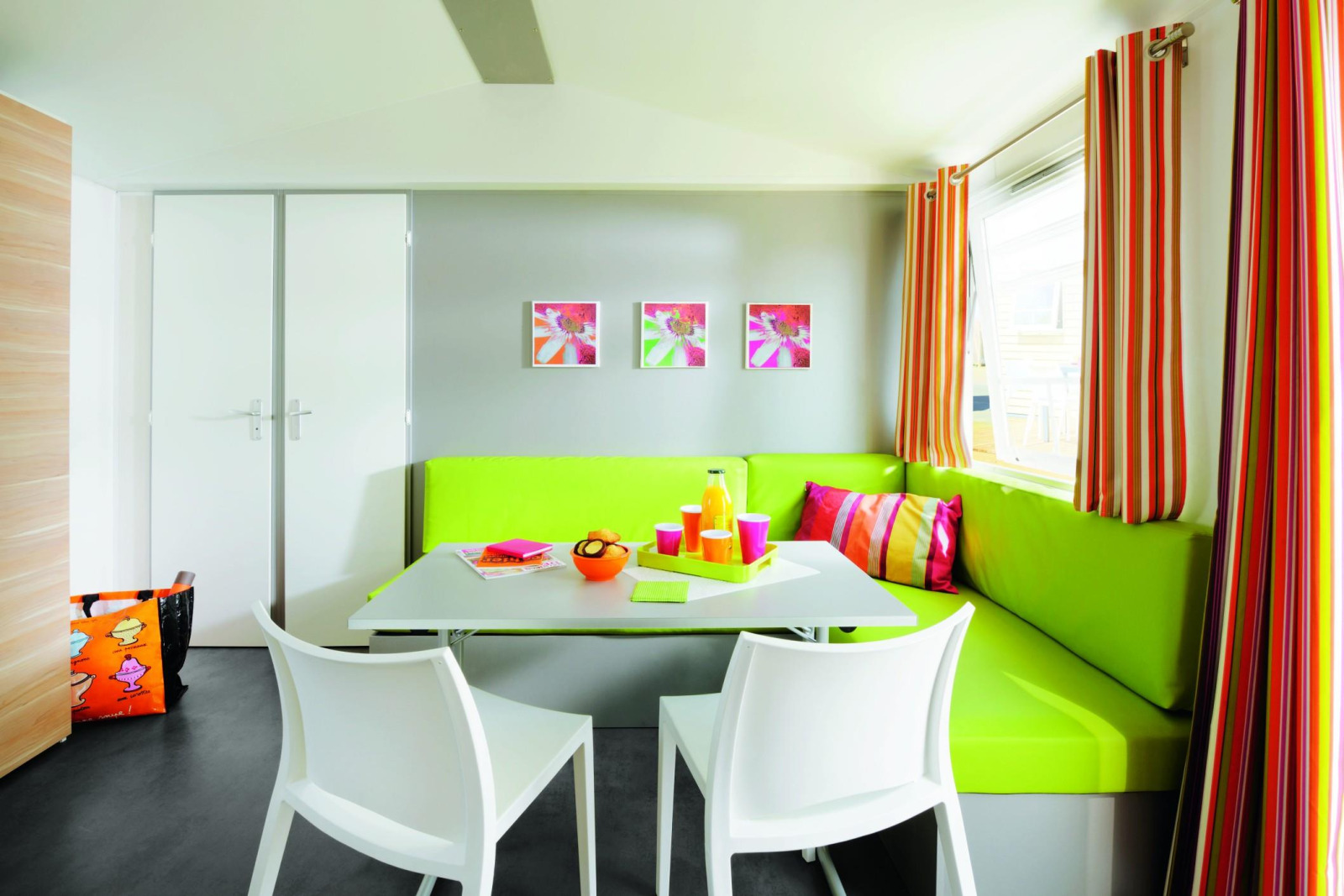 Kleurrijke eettafel in Stacaravan Confort, Flower Camping Au Bois Des Biches, Frankrijk, met modern interieur.