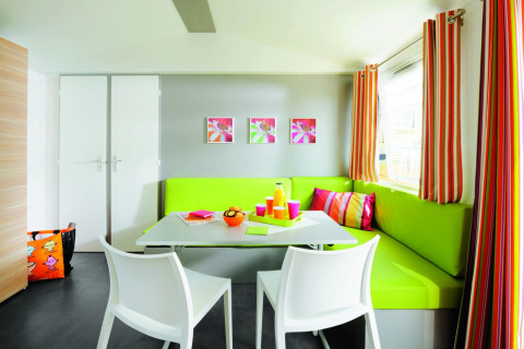 Farverig spiseplads på Stacaravan Confort, Flower Camping Au Bois Des Biches, med moderne indretning.