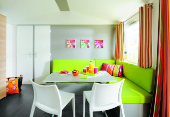 Bunter Essbereich im Stacaravan Confort, Flower Camping Au Bois Des Biches, mit moderner Einrichtung.