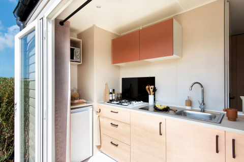 Angolo cottura moderno nello Stacaravan Confort al Flower Camping Au Bois Des Biches in Francia, porte aperte.