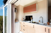 Moderne kitchenette in Stacaravan Confort bij Flower Camping Au Bois Des Biches in Frankrijk, open deur.