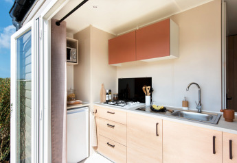 Moderne kitchenette in Stacaravan Confort bij Flower Camping Au Bois Des Biches in Frankrijk, open deur.