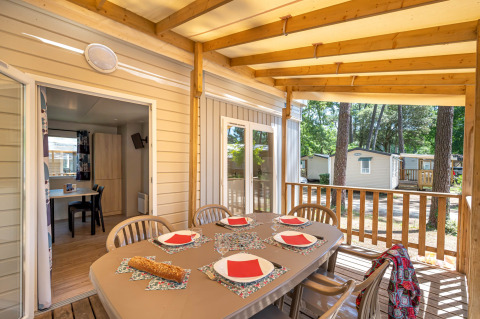 Overdekte veranda met gedekte tafel in Stacaravan Confort op Flower Camping Au Bois Des Biches, Frankrijk.